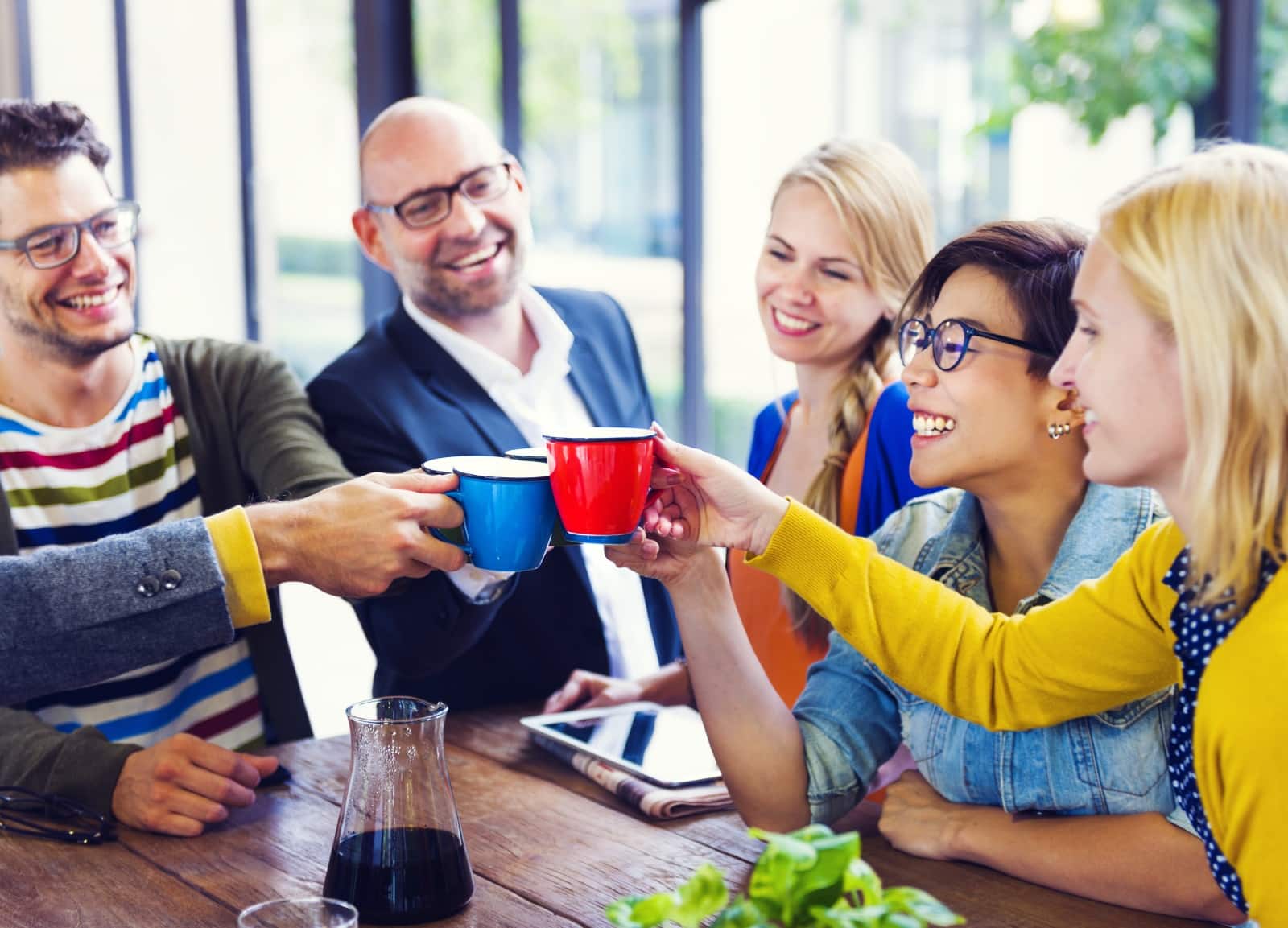 Group Of Casually Dressed Young Adults Raising Mugs