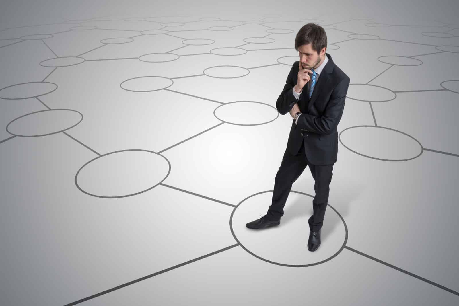 Man In Suit Contemplating Connected Circles On Ground